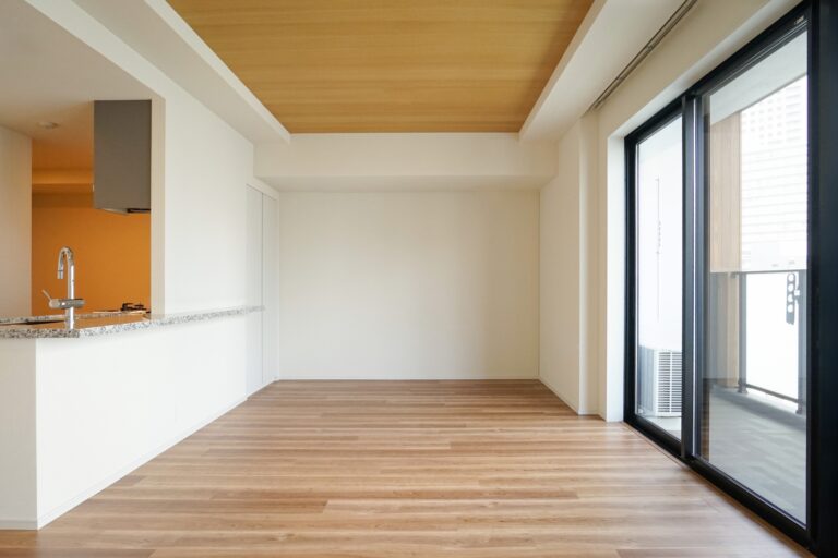 木目調の折り上げ天井とナチュラルなフローリングが美しい、対面式カウンターキッチン付きの明るいリビングダイニング。