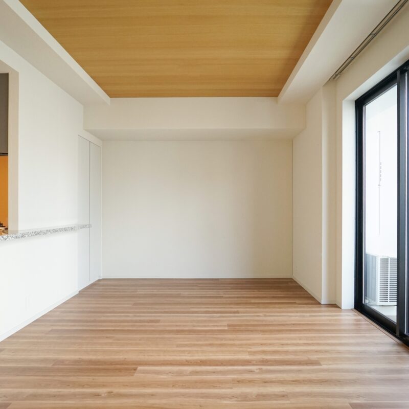 木目調の折り上げ天井とナチュラルなフローリングが美しい、対面式カウンターキッチン付きの明るいリビングダイニング。